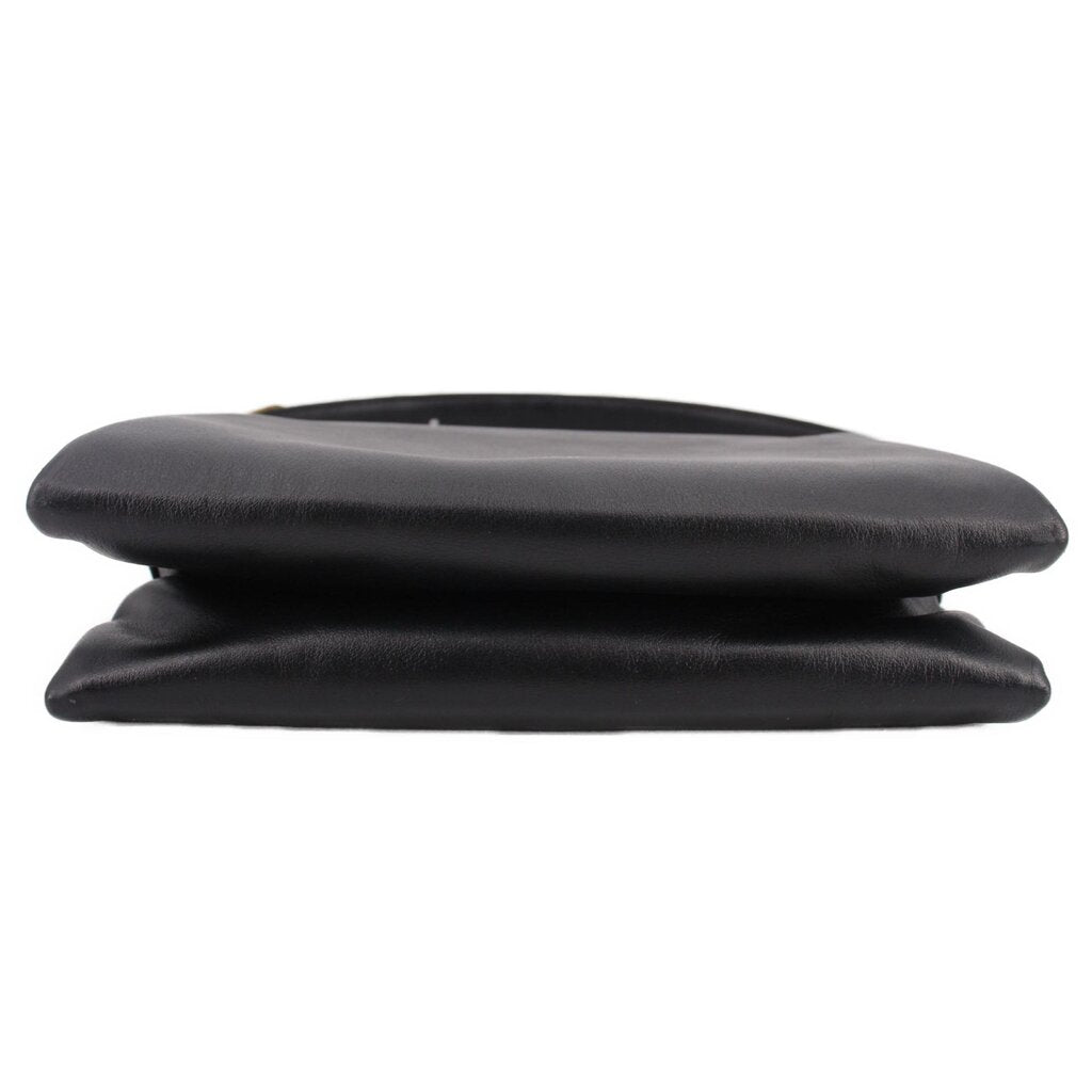 Black boxy crossbody bag close-up of layered flap top with smooth leather finish