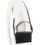 Black boxy crossbody bag worn crossbody with adjustable strap and flap front