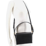 Black boxy crossbody bag worn crossbody with adjustable strap and flap front
