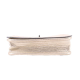 Coach Penny crossbody bag bottom edge, metallic gold leather with stitched trim.