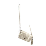 Coach Penny crossbody bag with pouch, metallic gold, hanging side view with long strap.