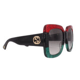Oversized sunglasses side view, dark lenses, red glitter front and black temple with GG logo
