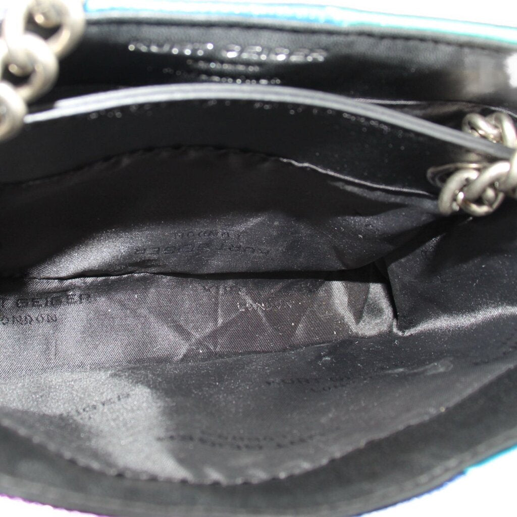 Black fabric-lined crossbody interior with chain hardware and zipper track