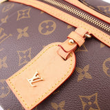Close-up of L-shaped leather charm on monogram belt bag with gold hardware