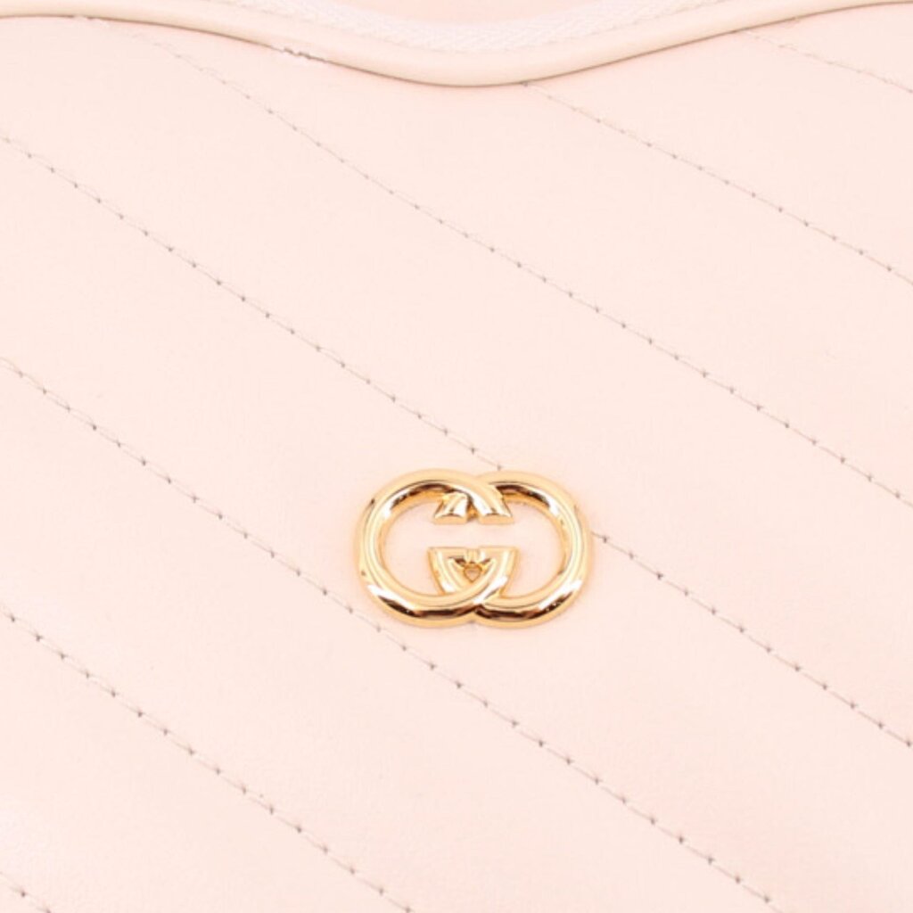 GUCCI cream heart crossbody bag close-up of GG heart emblem on quilting