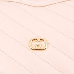 GUCCI cream heart crossbody bag close-up of GG heart emblem on quilting