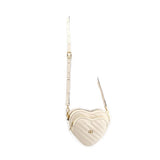 Cream heart-shaped crossbody bag with gold-tone hardware and adjustable strap