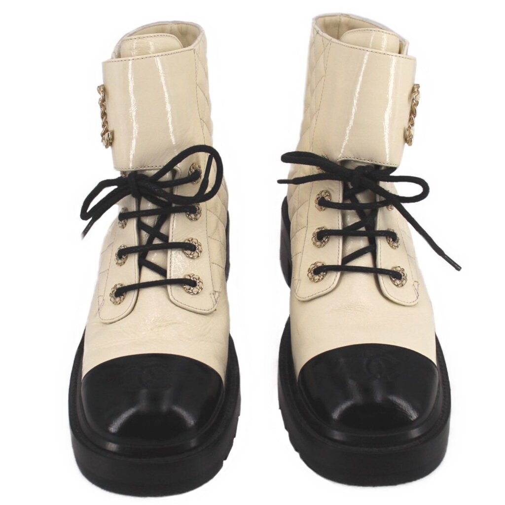 Pair of cream lace-up ankle boots with black toe caps and chunky soles