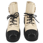Pair of cream lace-up ankle boots with black toe caps and chunky soles