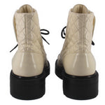 Cream quilted ankle boots with black soles, rear pull tabs, and lace-up closure