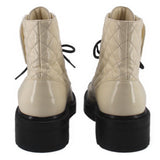 Cream quilted ankle boots with black soles, rear pull tabs, and lace-up closure