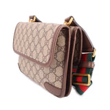 GUCCI GG canvas crossbody bag angled view with front pocket and striped web strap