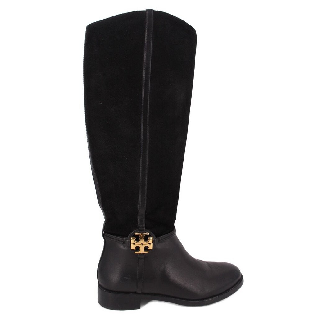 Black knee-high riding boots with side zipper and gold logo buckle at the cuff