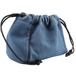Denim blue drawstring pouch with gathered top, black cords, and metal eyelet