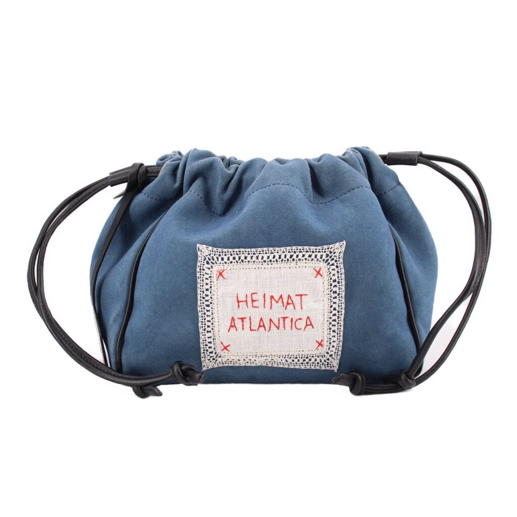Denim blue drawstring pouch with front logo patch and black cord handles