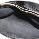 Black fabric-lined interior of shoulder bag with zip closure and braided trim