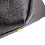 Black embossed hobo crossbody bag corner close-up with gold-tone stud