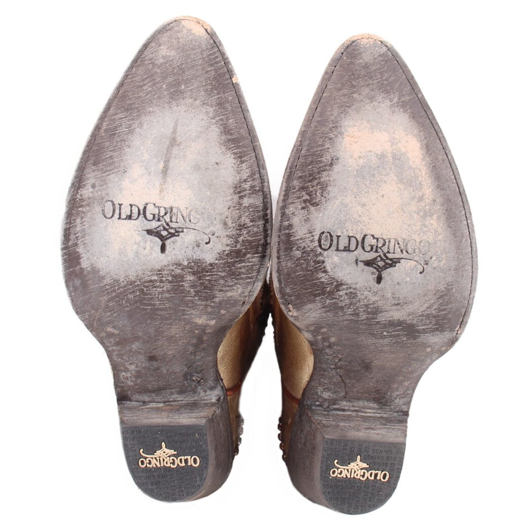 Bottom view of gold cowboy boots with treaded soles and OLDGRINGO logo