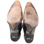 Women’s cowboy boot outsoles and heels in black with brown worn finish.