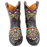 Pair of black women’s cowboy boots with vivid floral embroidery, pull-on, low heel.