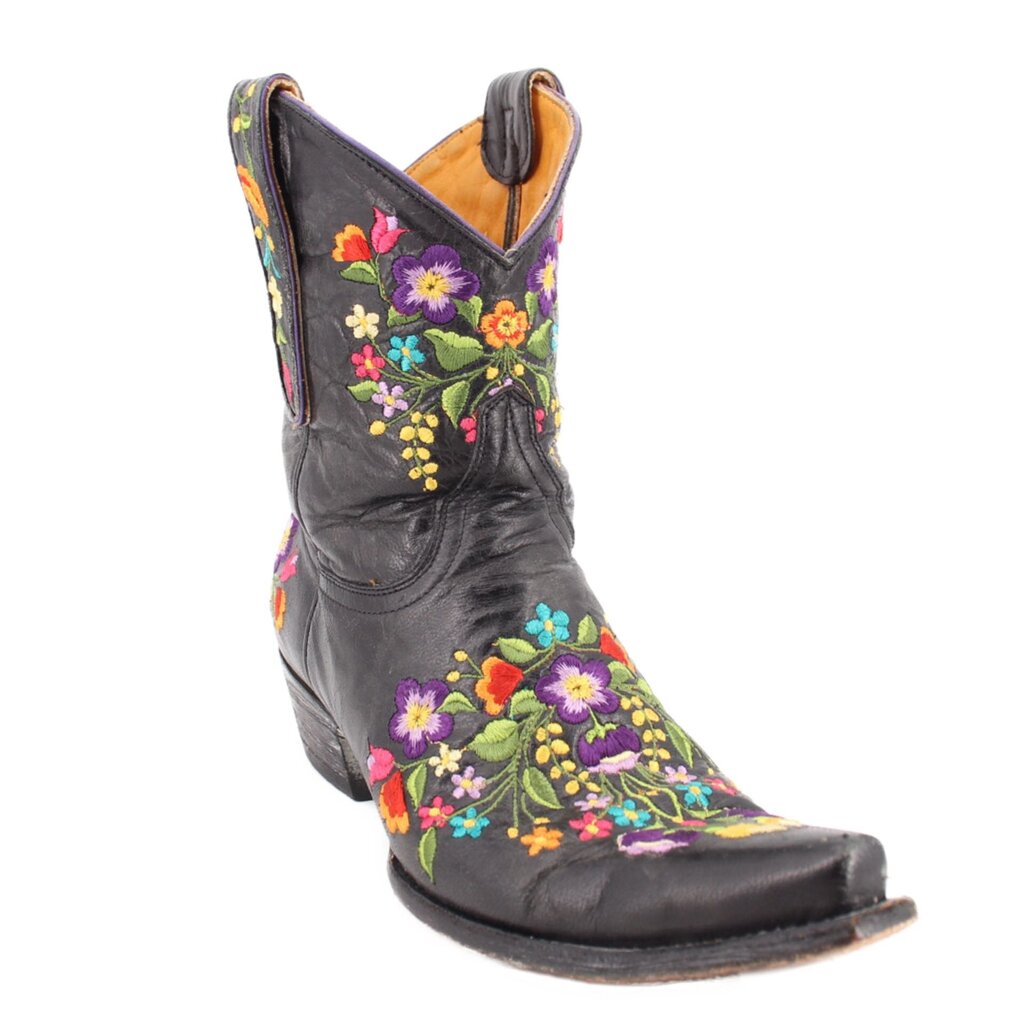 Black women’s cowboy boot with colorful floral embroidery, pull-on, pointed toe.
