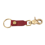 Red leather keychain with gold ring, round rivet detail, and swivel clasp hardware