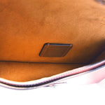 Interior of rose COACH crossbody bag lining with small leather brand patch