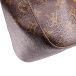 Louis Vuitton monogram shoulder bag side panel close-up with textured leather surface
