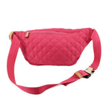 Pink quilted sling belt bag with curved shape, adjustable strap and gold zipper pulls