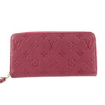 Empriente zip wallet in burgundy with gold-tone zipper and embossed monogram pattern.