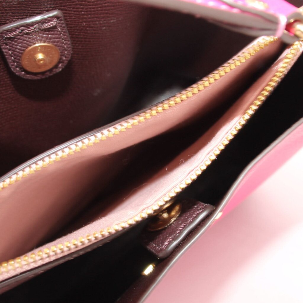 Fuchsia bucket bag interior detail with zipper track and stitched leather trim.