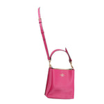 Coach Mollie bucket crossbody bag, fuchsia body with long strap and top handle.