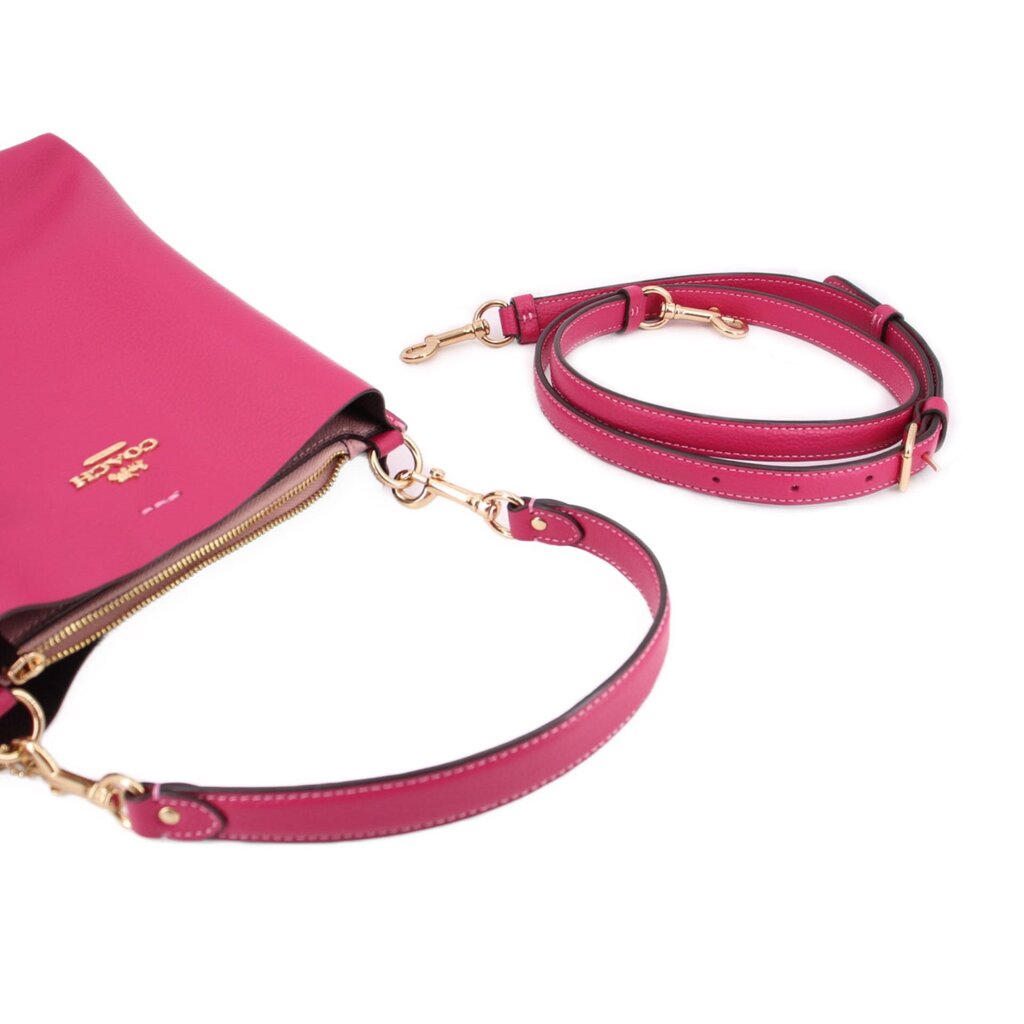 Coach Mollie bucket crossbody bag showing fuchsia straps with gold clasp hardware.