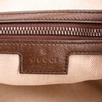 Brown leather trim and zipper hardware inside a GG canvas shoulder bag