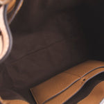Tan leather satchel interior with dark lining and stitched pocket