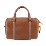 Brown woven satchel with dual top handles, vertical trim, and side zipper pocket.