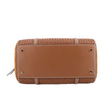 Brown woven satchel back panel with rivets, woven trim, and looped strap attachment.