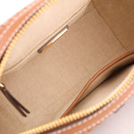 Satchel interior with tan lining and zip pocket, framed by brown leather trim.