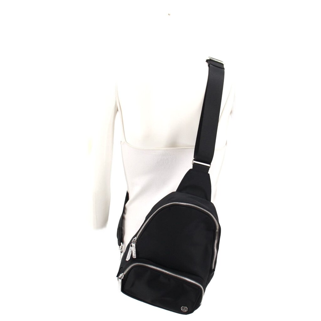 Black mini sling bag worn with adjustable shoulder strap