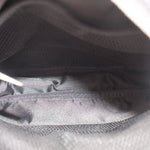 Interior view of black sling bag with mesh-lined pocket