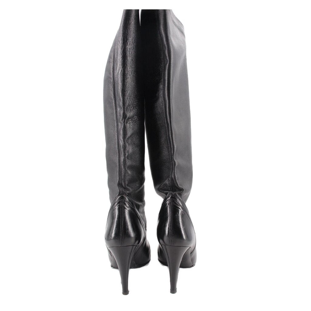 Knee-high leather boots showing back seams and stiletto heel, black