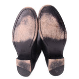 Black leather boot soles showing tread and brand marking