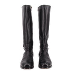 Pair of black leather tall boots with belted strap around lower shaft