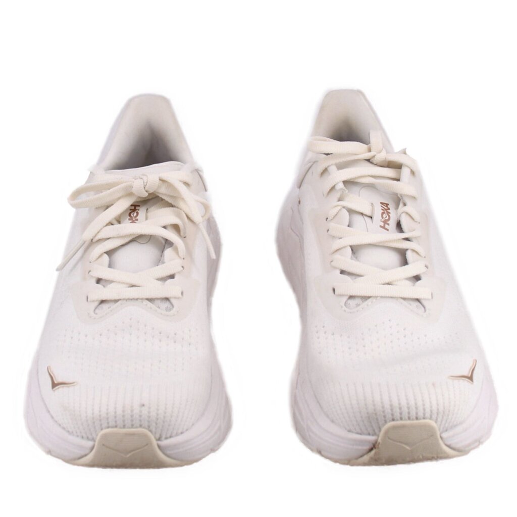Pair of white lace-up running sneakers with HOKA logo on side, knit upper