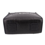 Black tote crossbody with embossed pattern and square patch detail on back