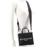 Black GIVENCHY mini G tote crossbody worn at side with adjustable strap