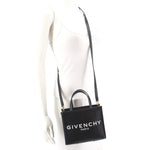 Black GIVENCHY mini tote crossbody with strap worn across shoulder