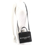 Black GIVENCHY mini tote crossbody with strap worn across shoulder
