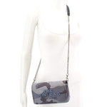 Gray camo mini crossbody bag worn on model with chain strap across chest