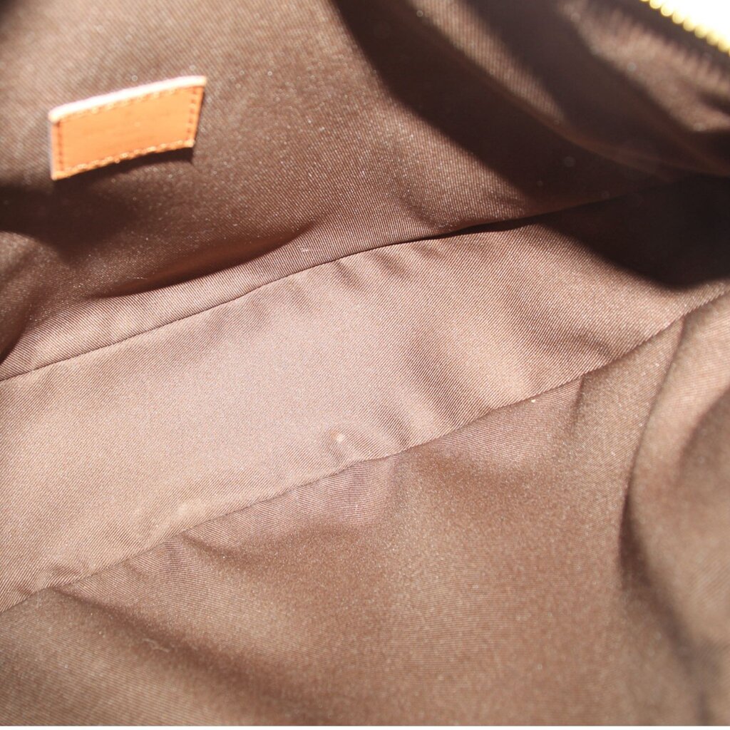 Crossbody bag interior lining in tan fabric with stitched seam